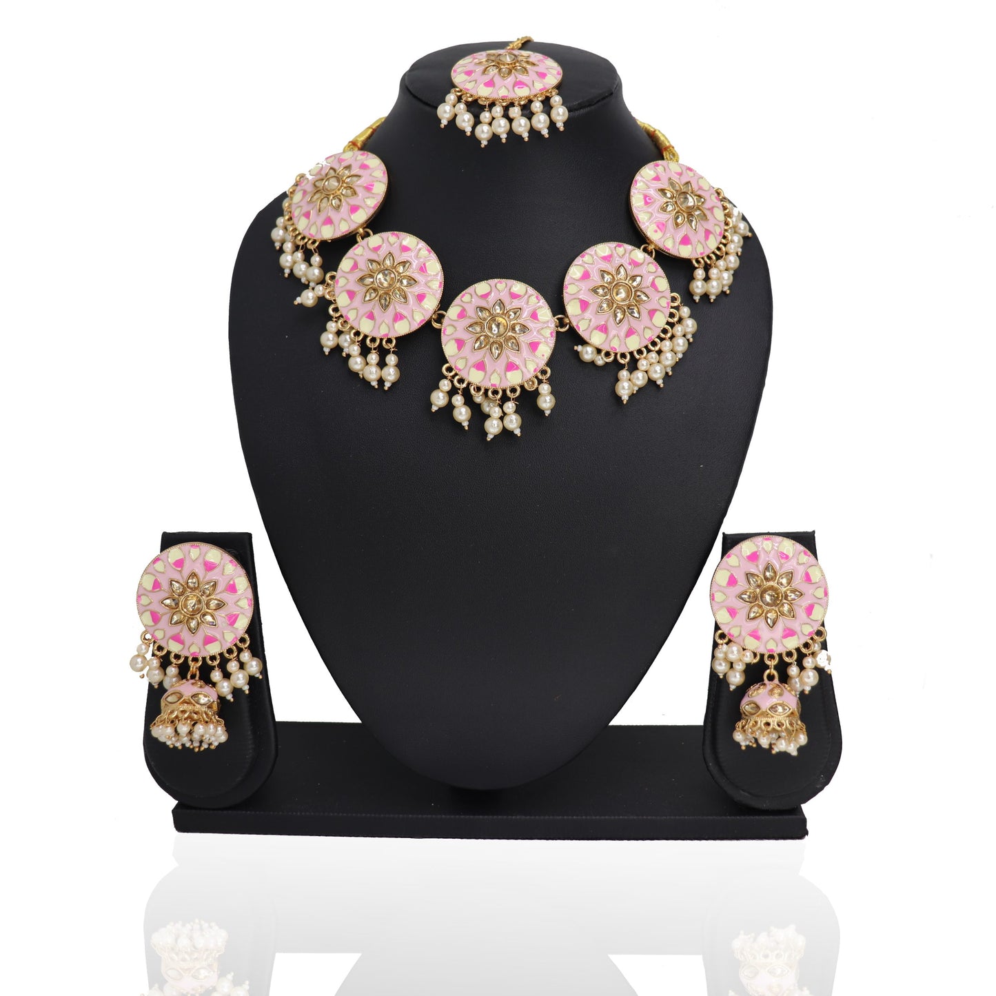 A baby pink Indian traditional choker set with floral patterns displayed on a black stand, including a necklace, earrings, and a mangtikka.