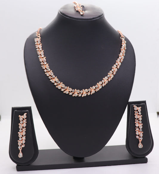A set of AD chokers, including a necklace, earrings, and a mangtikka, displayed on a black mannequin. The jewelry features a rose gold color with floral and leaf patterns adorned with rhinestones.