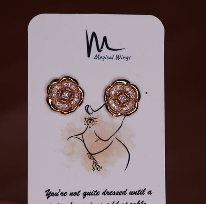 A pair of stud earrings with rose gold and white gold color scheme, featuring floral patterns and adorned with diamonds, presented on a branded card.