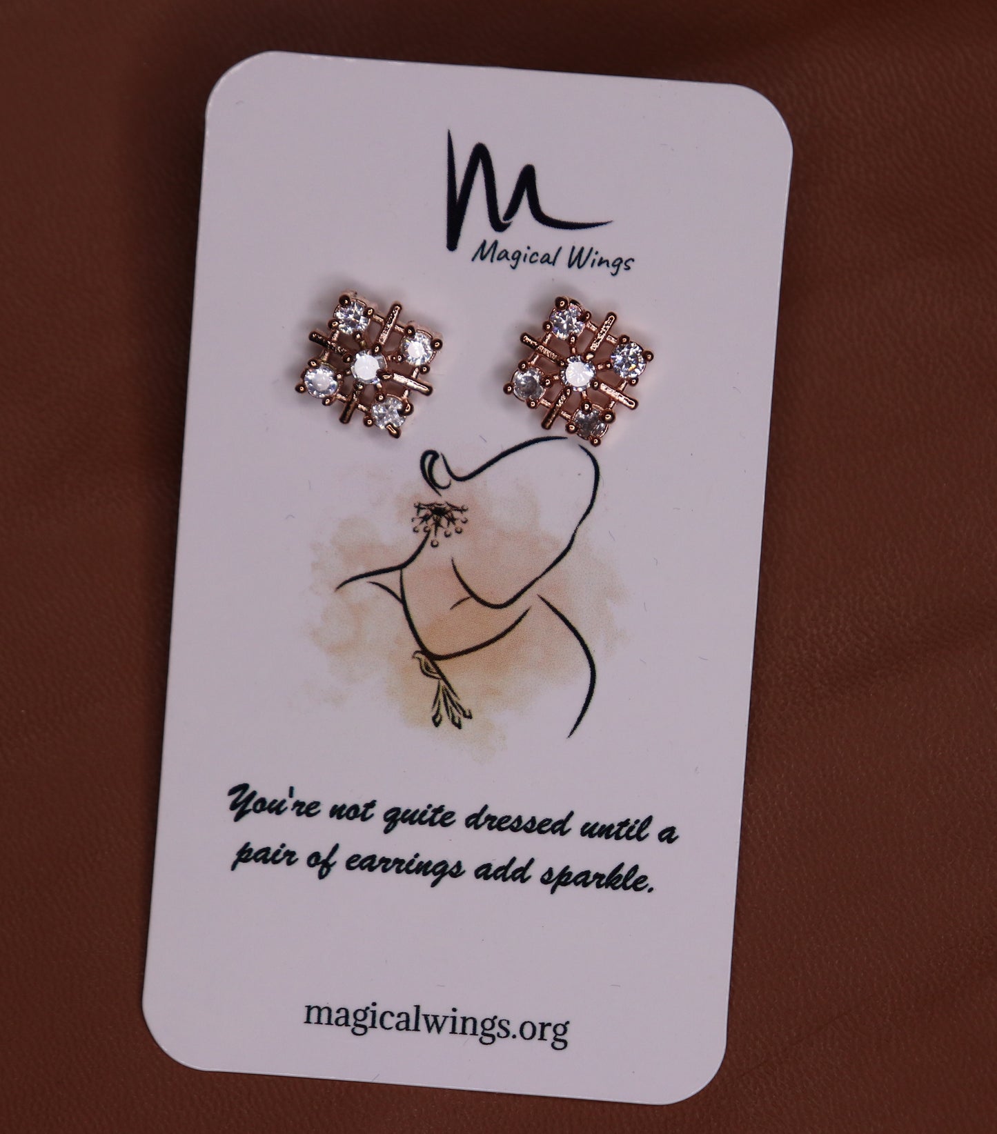 A pair of floral stud earrings with AD embellishments presented on a card with 'Magical Wings' branding.