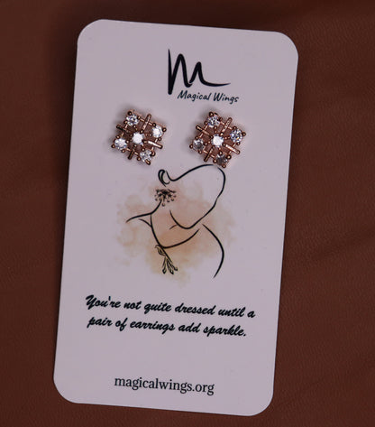 A pair of floral stud earrings with AD embellishments presented on a card with 'Magical Wings' branding.