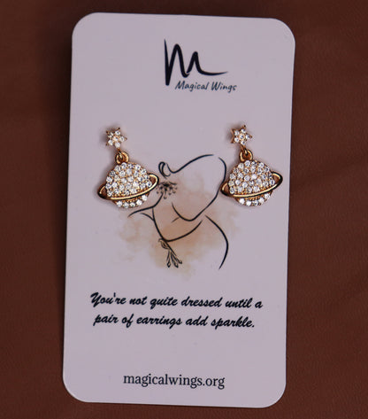 A pair of AD (acrylic) earrings on a card with the Magical Wings logo, featuring a gold-tone stud with a floral design and clear acrylic embellishments.