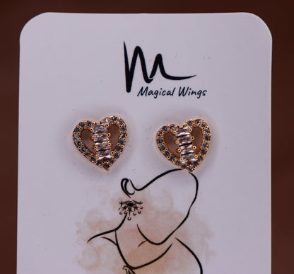 A pair of heart-shaped stud earrings with AD embellishments, displayed on a card with the brand name Magical Wings.