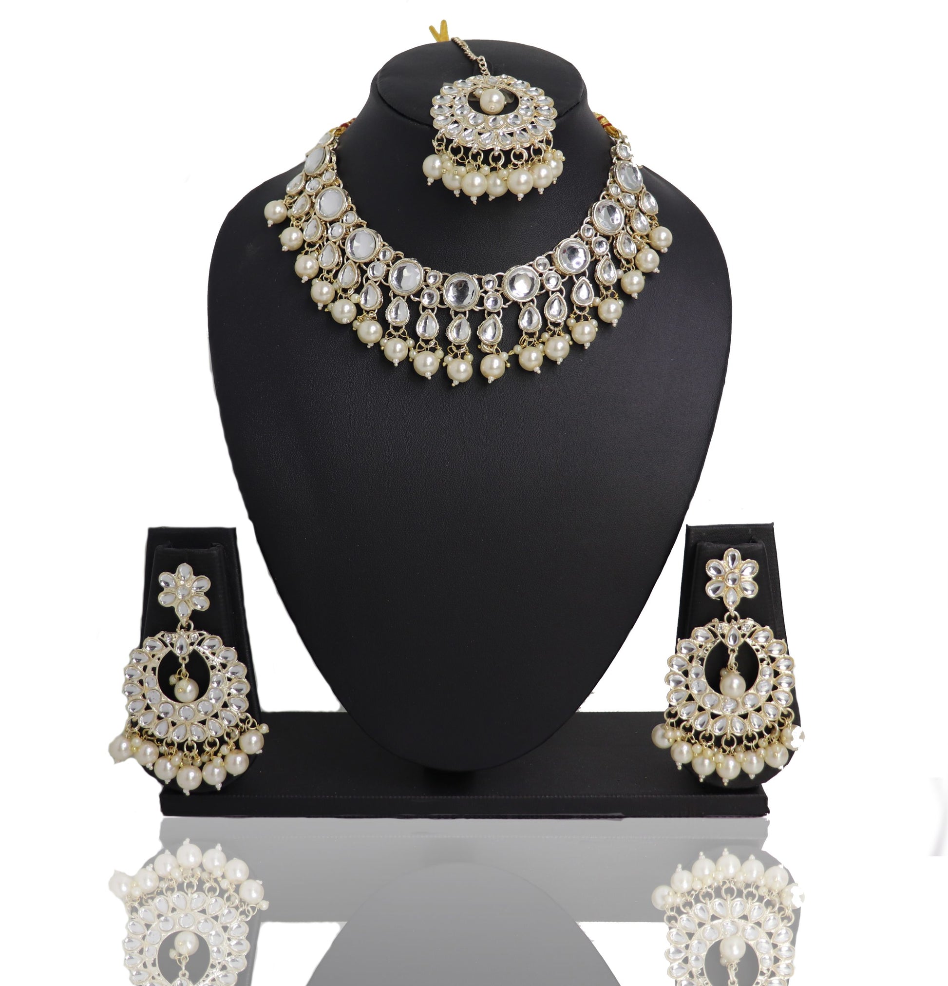 A Pearl Monalisa Choker Set displayed on a mannequin bust, consisting of a necklace, earrings, and a mangtikka, with a reflective white surface and gold accents.