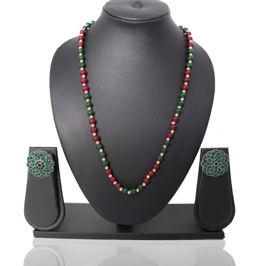 A red and green bead necklace set displayed on a mannequin, including a matching necklace, earrings, and a ring.