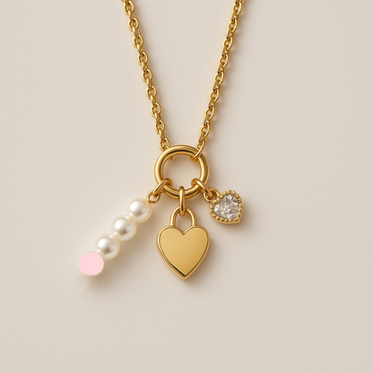 Gold necklace with heart, lock, and pearl charm on a beige background