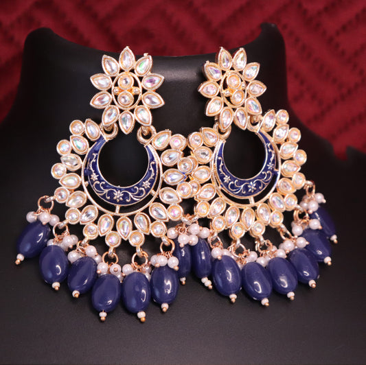A pair of Chandbali earrings featuring a meenakari kundan style with dark blue color accents and pearl drops.