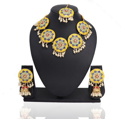 A yellowish gujjan choker set displayed on a mannequin bust, consisting of a necklace, earrings, and a mangtikka with floral and geometric patterns.