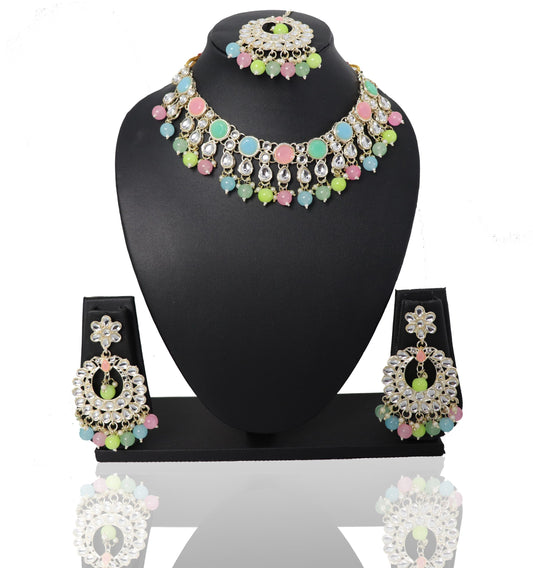 A set of jewelry featuring a multicolored choker necklace, matching earrings, and a maangtikka, displayed on a black mannequin.