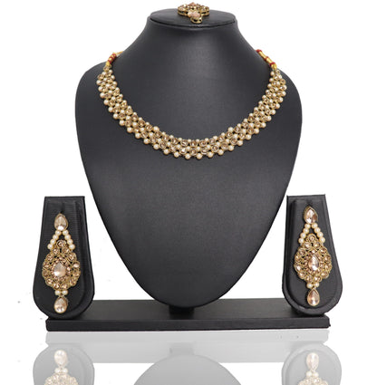 A golden Payal Kundan Choker Set displayed on a black mannequin bust, including a necklace with pendants and earrings with pendants.