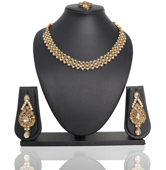 A golden Payal Kundan Choker Set displayed on a black mannequin bust, including a necklace with pendants and earrings with pendants.