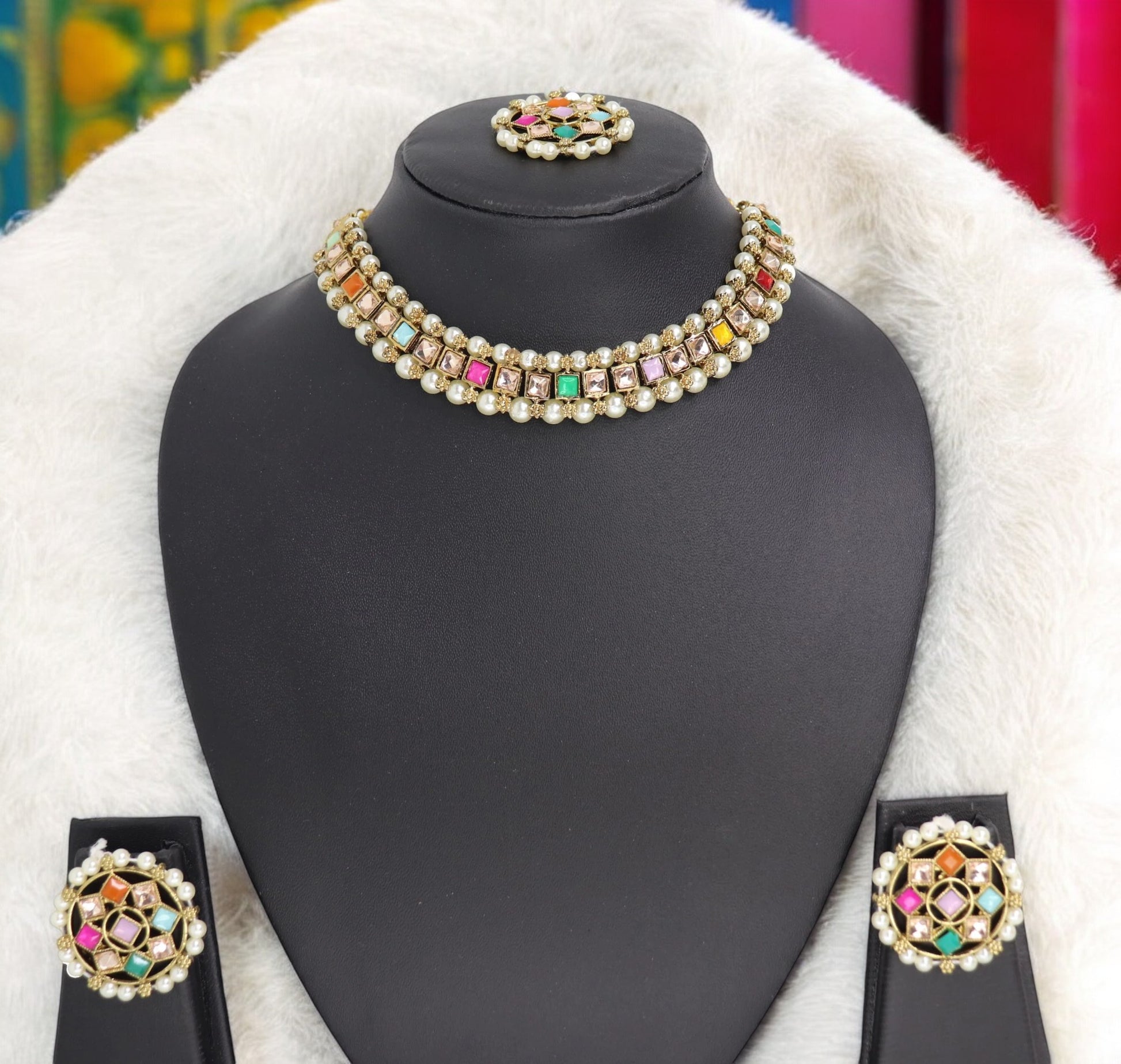 A choker necklace set with multicolored kundan-style pearls displayed on a mannequin bust, complemented by a matching pair of earrings.