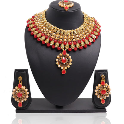 A red and gold necklace set with a pendant and earrings displayed on a mannequin bust.