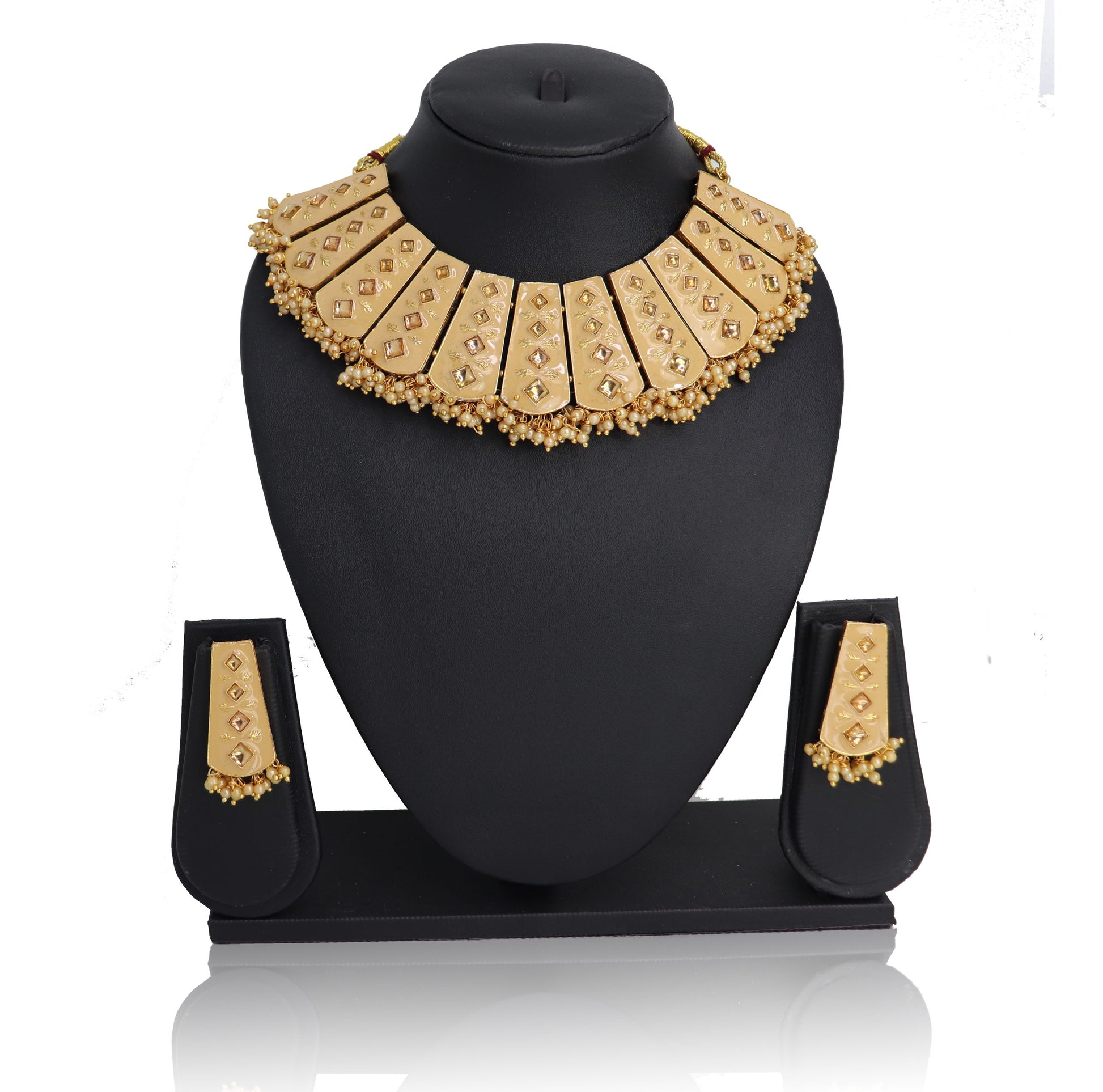 A Necklace set with a golden-colored beaded chain and matching earrings displayed on a black stand.