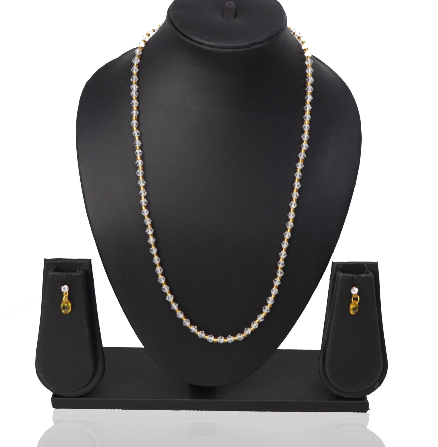 A necklace and three earrings set displayed on a mannequin, featuring white beads and gold-colored accents.