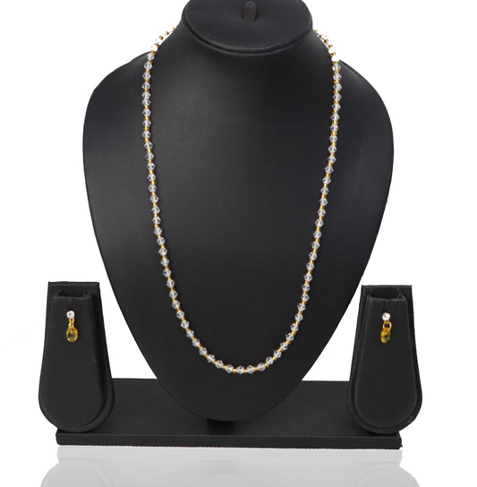 A necklace and three earrings set displayed on a mannequin, featuring white beads and gold-colored accents.