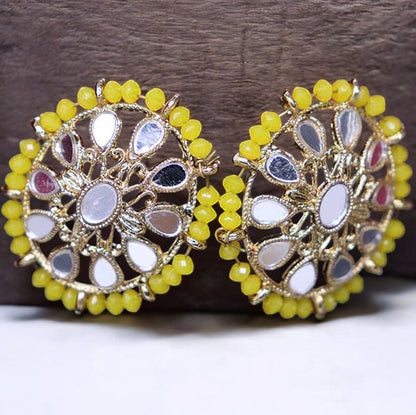A pair of yellowish stud earrings with intricate designs and small yellow beads around the edge.